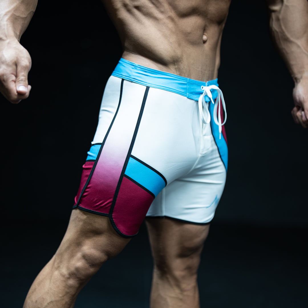 Muscular male athlete wearing Oasis teal, burgundy, and white Men&