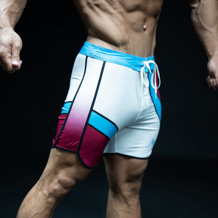 Muscular male athlete wearing Oasis teal, burgundy, and white Men&