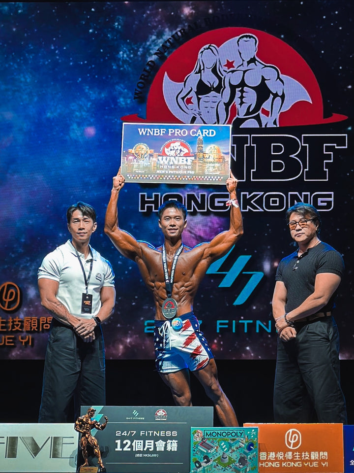 IFBB Elite Pro Ali Bilal on stage at WNBF Hong Kong wearing Freedom navy, white, and red American flag Men&